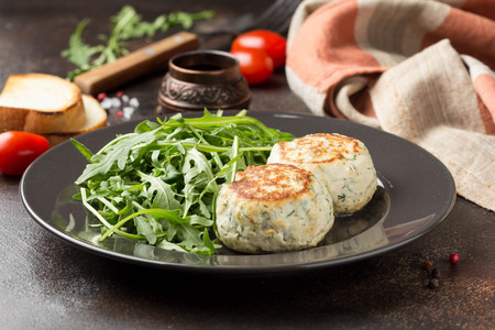 Fried chicken cutlet with herbs, delicious healthy lunch, children's food, diet. Meatballs with salad on dark backgroundの写真素材
