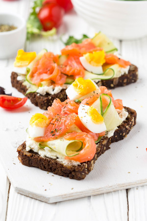 Salmon toast with cream cheese, cucumber and egg. Delicious lunch, healthy food, fish sandwich, diet snackの写真素材