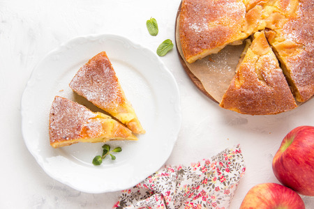 Apple pie with powdered sugar, classic Charlotte, biscuit dough. Golden brown, homemade foodの写真素材