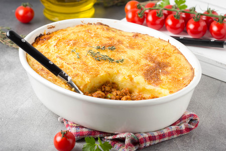 Shepherds pie with a brown crust, meat tomato stew with green peas and mashed potatoes with cheese. Delicious food, home cookingの写真素材