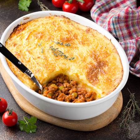 Shepherds pie with a brown crust, meat tomato stew with green peas and mashed potatoes with cheese. Delicious food, home cookingの写真素材