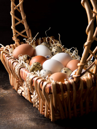 Different eggs in the basket, white, dark, quail and chicken. Easter holidayの写真素材