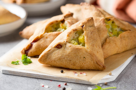 Tatar pie triangle echpochmak, Russian kurnik, delicious pastry with chicken and potatoes. Traditional food, quick snack of doughの写真素材