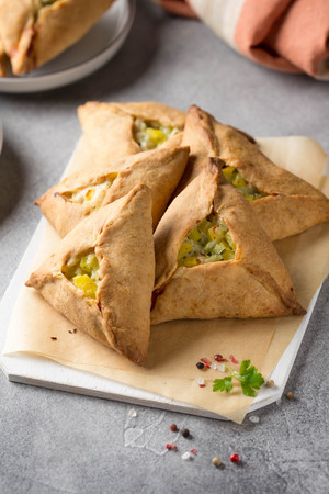 Tatar pie triangle echpochmak, Russian kurnik, delicious pastry with chicken and potatoes. Traditional food, quick snack of doughの写真素材