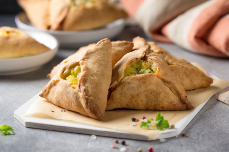 Tatar pie triangle echpochmak, Russian kurnik, delicious pastry with chicken and potatoes. Traditional food, quick snack of doughの写真素材