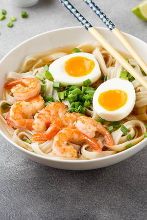 Japanese soup with wheat noodles, fried shrimp, soft-boiled egg with liquid yolk and green onions. Traditional Asian ramen, delicious lunch, healthy foodの写真素材