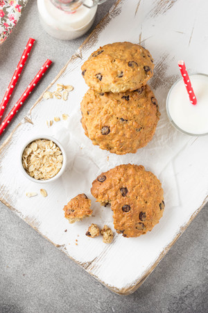 Homemade oatmeal cookies with chocolate and banana, milk in a glass with a tube. Delicious dessert, Breakfast (lunch), healthy food, pastries for childrenの写真素材