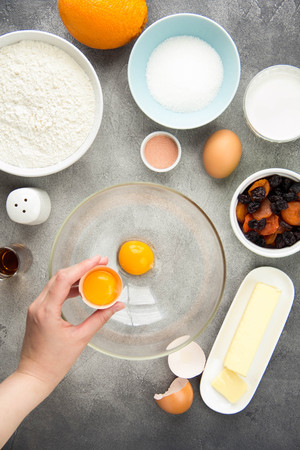 Ingredient for cooking easter cakes with icing, orange, dried fruits, spring holiday. Flour, milk, sugar, raisins, dried apricots, egg yolksの写真素材