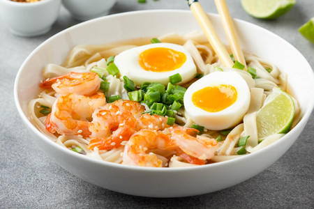 Japanese soup with wheat noodles, fried shrimp, soft-boiled egg with liquid yolk and green onions. Traditional Asian ramen, delicious lunch, healthy foodの写真素材