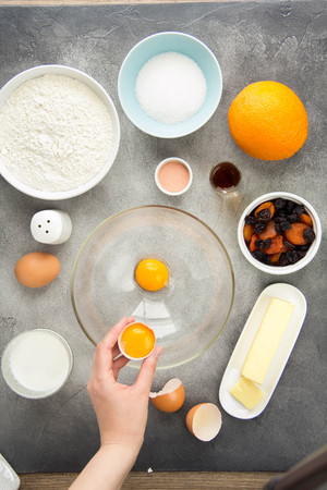 Ingredient for cooking easter cakes with icing, orange, dried fruits, spring holiday. Flour, milk, sugar, raisins, dried apricots, egg yolksの写真素材