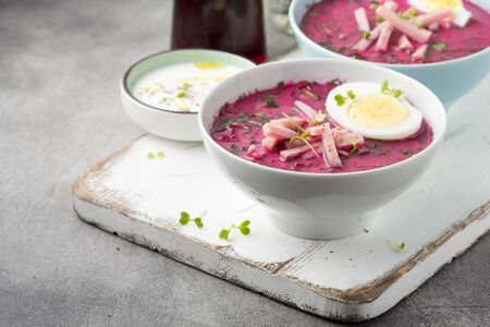 Cold beet soup, traditional Lithuanian dish, summer food. Fresh vegetables (cucumbers, radishes, green onions, cilantro), sour cream, yogurt, egg, hamの写真素材