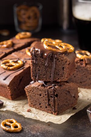 Chocolate brownie on dark beer with salted pretzels and chocolate. Delicious brutal dessert for men, sweet foodの写真素材