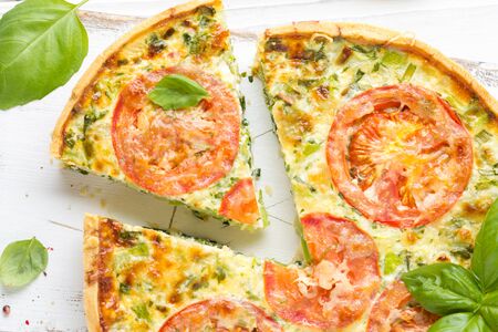 Quiche with vegetables (squash, tomatoes, cheese, herbs, green onions), open tart, French cuisine, traditional pastries, tastyの写真素材