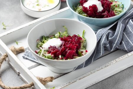 Cold beet soup, traditional Lithuanian dish, summer food. Fresh vegetables (cucumbers, radishes, green onions, cilantro), sour cream, yogurt, egg, hamの写真素材