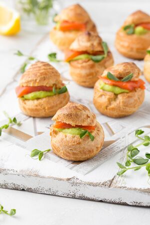 Snack cakes profiteroles with green pea cream and salmon red fish. Exquisite appetizer, a tasty lunch, traditional foodの写真素材
