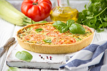 Quiche with vegetables (squash, tomatoes, cheese, herbs, green onions), open tart, French cuisine, traditional pastries, tastyの写真素材