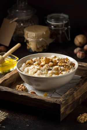 Oatmeal with nuts (hazelnuts, walnuts) and honey, porridge for Breakfast. Tasty and healthy foodの写真素材