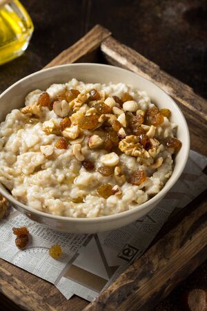 Oatmeal with nuts (hazelnuts, walnuts) and honey, porridge for Breakfast. Tasty and healthy foodの写真素材
