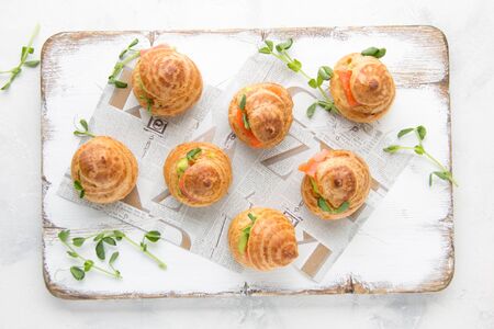 Snack cakes profiteroles with green pea cream and salmon red fish. Exquisite appetizer, a tasty lunch, traditional foodの写真素材