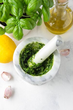 Green marinade in a mortar of herbs Basil, parsley, nuts. Delicious traditional sauceの写真素材