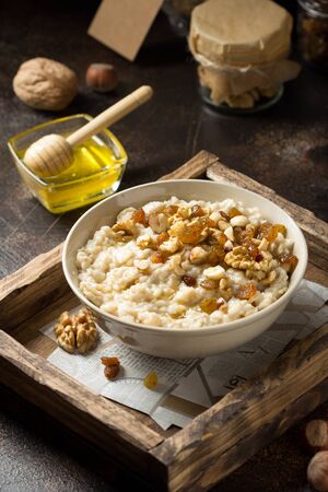 Oatmeal with nuts (hazelnuts, walnuts) and honey, porridge for Breakfast. Tasty and healthy foodの写真素材