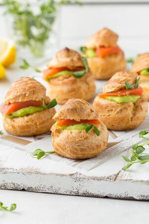 Snack cakes profiteroles with green pea cream and salmon red fish. Exquisite appetizer, a tasty lunch, traditional foodの写真素材