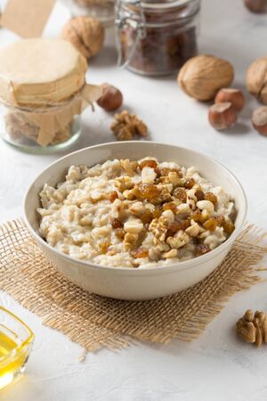 Oatmeal with nuts (hazelnuts, walnuts) and honey, porridge for Breakfast. Tasty and healthy foodの写真素材