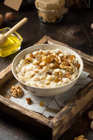 Oatmeal with nuts (hazelnuts, walnuts) and honey, porridge for Breakfast. Tasty and healthy foodの写真素材