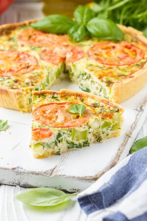 Quiche with vegetables (squash, tomatoes, cheese, herbs, green onions), open tart, French cuisine, traditional pastries, tastyの写真素材