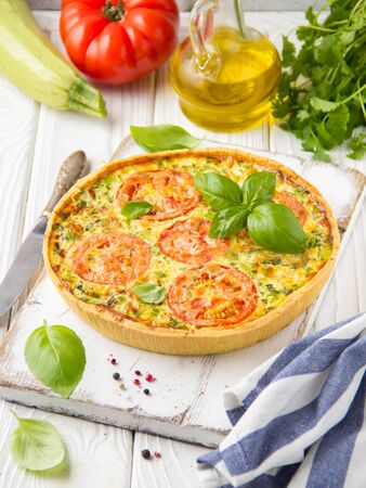 Quiche with vegetables (squash, tomatoes, cheese, herbs, green onions), open tart, French cuisine, traditional pastries, tastyの写真素材