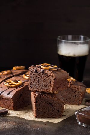 Chocolate brownie on dark beer with salted pretzels and chocolate. Delicious brutal dessert for men, sweet foodの写真素材
