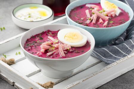 Cold beet soup, traditional Lithuanian dish, summer food. Fresh vegetables (cucumbers, radishes, green onions, cilantro), sour cream, yogurt, egg, hamの写真素材