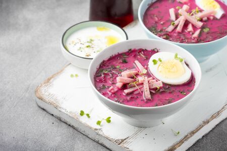 Cold beet soup, traditional Lithuanian dish, summer food. Fresh vegetables (cucumbers, radishes, green onions, cilantro), sour cream, yogurt, egg, hamの写真素材