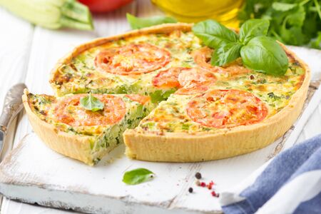 Quiche with vegetables (squash, tomatoes, cheese, herbs, green onions), open tart, French cuisine, traditional pastries, tastyの写真素材
