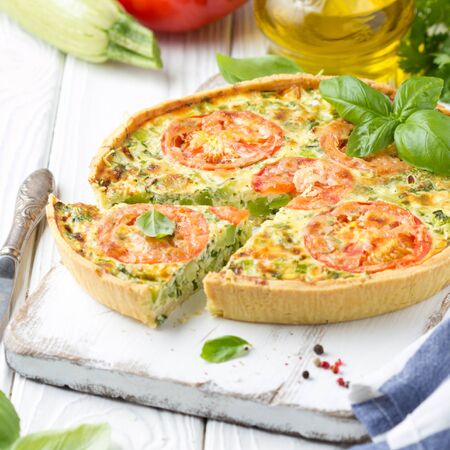Quiche with vegetables (squash, tomatoes, cheese, herbs, green onions), open tart, French cuisine, traditional pastries, tastyの写真素材