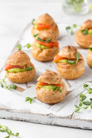 Snack cakes profiteroles with green pea cream and salmon red fish. Exquisite appetizer, a tasty lunch, traditional foodの写真素材