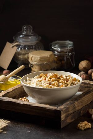 Oatmeal with nuts (hazelnuts, walnuts) and honey, porridge for Breakfast. Tasty and healthy foodの写真素材