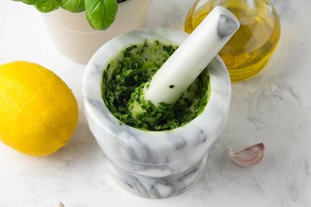 Green marinade in a mortar of herbs Basil, parsley, nuts. Delicious traditional sauceの写真素材