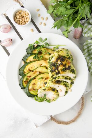 Grilled chicken fillet with green herb marinade, with slices of fried zucchini and pine nuts, delicious healthy lunchの写真素材