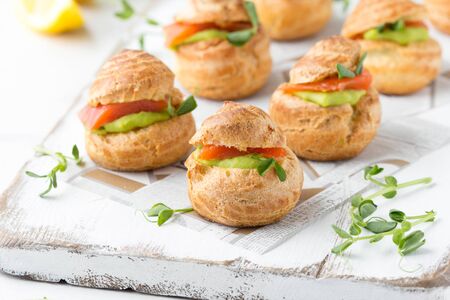 Snack cakes profiteroles with green pea cream and salmon red fish. Exquisite appetizer, a tasty lunch, traditional foodの写真素材