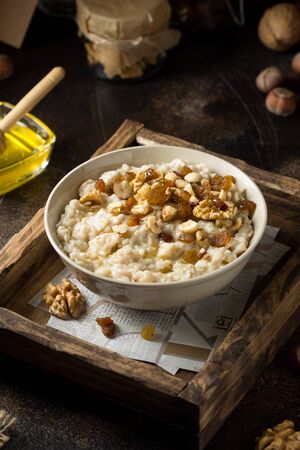Oatmeal with nuts (hazelnuts, walnuts) and honey, porridge for Breakfast. Tasty and healthy foodの写真素材