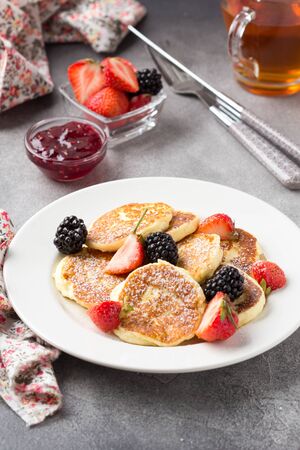 Cheesecakes, pancakes with berries, traditional Russian Breakfast of cottage cheese. Delicious sweet dessert, healthy foodの写真素材