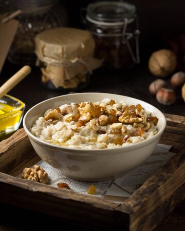 Oatmeal with nuts (hazelnuts, walnuts) and honey, porridge for Breakfast. Tasty and healthy foodの写真素材