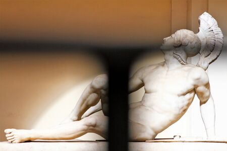 Marble statue of a lying warrior. Image seen through an iron grateの写真素材