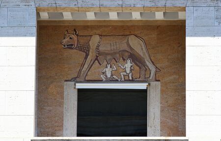 Facade of building in the historic center of Rome. Marble mosaic representing the Roman she-wolf with the little Romole and Remo.の写真素材