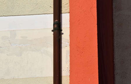 Italian urban architecture, portion of a residential building, dark red and cream plaster, copper...
