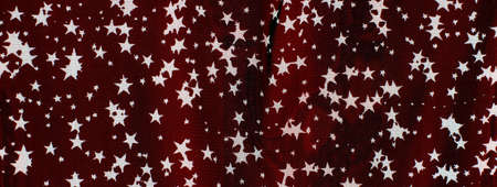 Tulle fabric with designs of white stars on a red backgroundの写真素材
