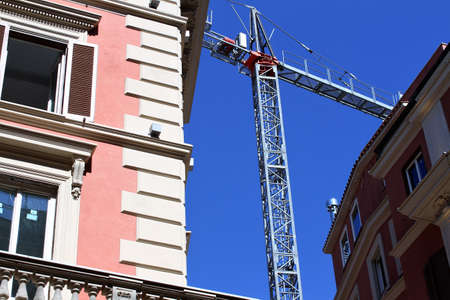 Renovation works in a residential area of â€‹â€‹Rome, a crane transports cargo,...