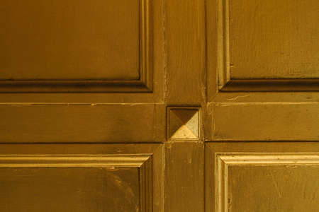 Detail of a gold-colored door, highlights and shadows.の写真素材
