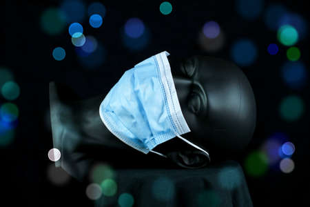 3d illustration. Reclining head of dark plastic mannequin with face mask, artificial bubbles and black backgroundの写真素材